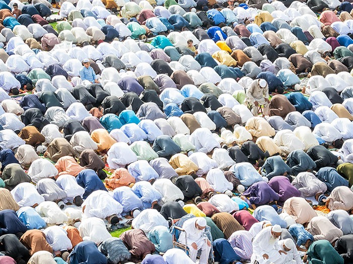 Muslims praying wearing various colors.
