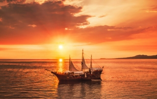 Old ship at sunset at sea