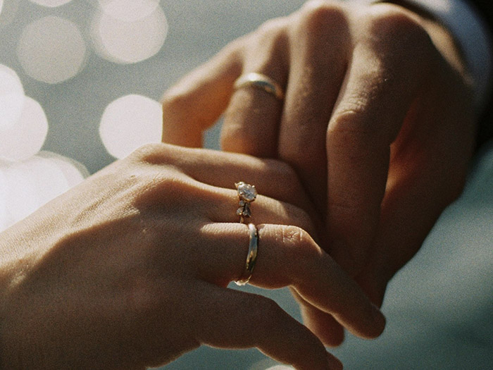 A married couple touching hands.